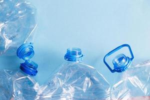 a lot of plastic empty rumpled used bottles on a blue background. waste and pollution concept photo