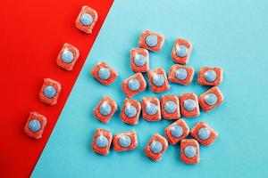 capsules for kitchen dishwashers on a blue and red background. flat lay. photo