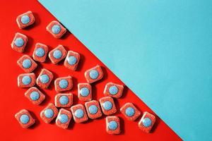 capsules for kitchen dishwashers on a blue and red background. flat lay. photo