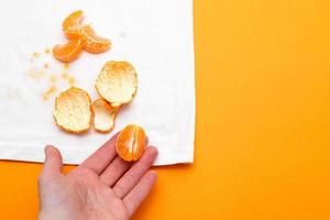 female hand holding white clothes with ditry stains from fruits mandarin photo