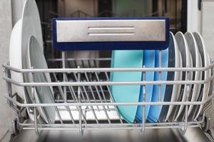 Open dishwasher with clean dishes in the kitchen photo