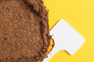 soil texture close up. mock up. coconut briquette with writing boards on a orange background. photo