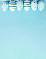 easter colorful handmade painted eggs on blue background with copy space. banner photo