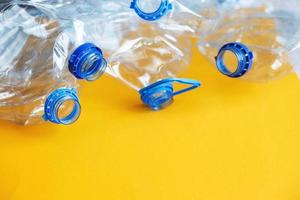 a lot of plastic empty rumpled used bottles on a yellow background. waste and pollution concept photo
