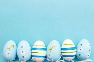 easter colorful handmade painted eggs on blue background with copy space photo