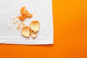 manchas sucias en ropa blanca de frutas mandarina sobre fondo naranja foto