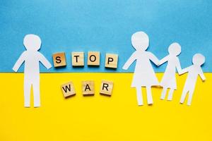 paper cut divided family on the background of the ukrainian flag. stop war concept photo