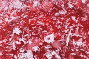 Mashed red fresh frozen strawberries background closeup