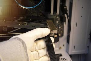 Technician repairing computers, connecting wires to computers photo