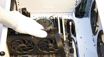 Technician repairing computer, installing video card photo