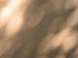 Abstract texture of a shadow on a beige weathered and cracked wall photo