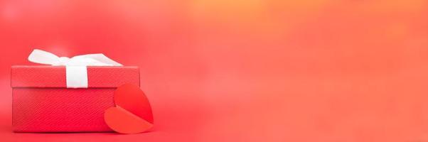 Present box with a heart on a red background. photo