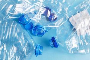 a lot of plastic empty rumpled used bottles on a blue background. waste and pollution concept photo