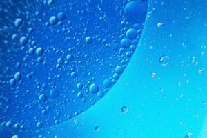 abstract light blue background with oil circles . bubbles of water close up . photo