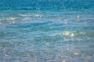 Blue sea with reflections on the water and light waves as a background. Sea background. photo