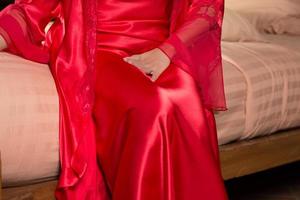 A woman in a red satin nightgown urinating frequently at night. photo