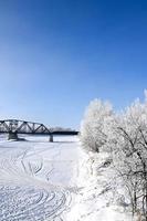 un puente ferroviario sobre un río congelado