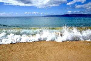 waves crashing on a beach in Maui photo