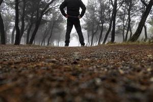 hombre en bosque con niebla foto