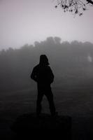 hombre en bosque con niebla foto