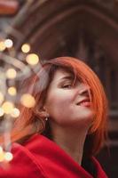 Close up attractive redhead lady and fairy lights on street portrait picture photo