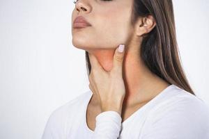 Young beautiful woman suffering from pain in throat, touching inflamed zone on her neck, cropped, empty space, sore throat photo