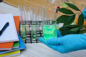 Closeup student hand wears blue glove, doing science experiment, lab lesson, holds test tube. Concept, science subject, project work. Experiment, education, learning by doing approach. photo