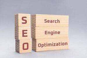 SEO Search Engine Optimization text on wooden blocks on gray background photo