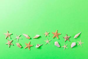 A lot of seashells and starfishon green background with copy space photo