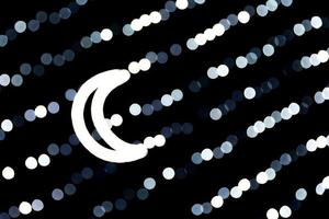 Abstract bokeh of white city lights on black background. defocused and blurred with moon of lights photo