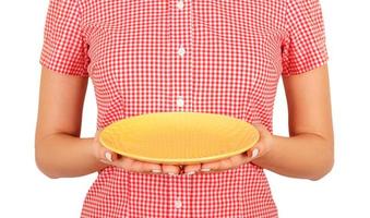 cafe worker points at the camera with an empty round yellow plate in front of him. perspective view Template for your design. isolated on white background photo