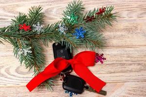 Close-up view of car keys with red bow as present on wooden background photo