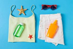 Flat lay composition with Beach accessories on blue color background. Summer holiday background. Vacation and travel items top view photo