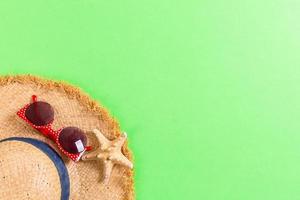 Beach hat with seashells on brown green table. summer background concept with copy space top view photo