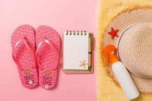 Flat lay, top view Travel concept. summer accessories with note paper and seashell on pink background photo