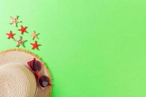 Beach hat with seashells on brown green table. summer background concept with copy space top view photo