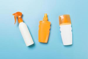 flat lay concept of summer travel vacation. Sunscreen bottle mock up on blue background top view with copy space photo