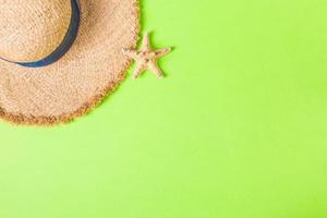 yellow retro straw hat with seastar top view with copy space. summer concept on green background photo