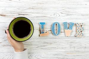 mujer con taza de café caliente, con galletas. concepto de amor palabra de amor con cafe foto