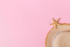 yellow retro straw hat with seastar top view with copy space. summer concept on pink background photo