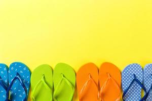 un montón de sandalias de colores flip flop, vacaciones de verano sobre fondo de color, vista superior del espacio de copia foto