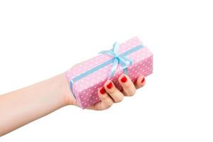 Woman hands give wrapped Christmas or other holiday handmade present in pink paper with blue ribbon. Isolated on white background, top view. thanksgiving Gift box concept photo