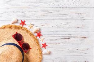 summer holiday beach background with accessories on wooden table, top view with copy space. vacation concept photo