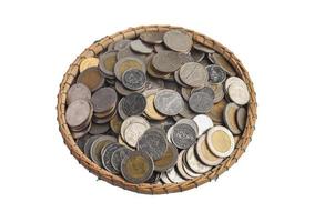 monedas en una cesta de bambú sobre un fondo blanco. concepto de ahorro de dinero foto