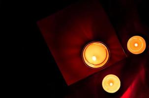 Scented candles in the dark night on a red cloth, ceremony, hope, romantic photo