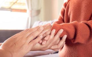 primer plano de la madre sosteniendo la mano del bebé en casa para alentar y esperar, concepto de familia feliz foto