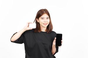 sosteniendo una tarjeta bancaria en blanco y un teléfono inteligente de pantalla en blanco de una hermosa mujer asiática aislada en blanco foto