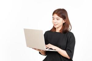 cara feliz mientras usa la computadora portátil de una hermosa mujer asiática aislada de fondo blanco foto