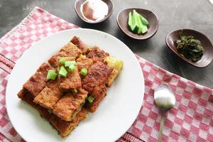 Martabak Telor or Murtabak Telur or mutabbaq. Savory pan-fried pastry stuffed with egg, meat and spices. Martabak Telur is one of Indonesia street food. photo