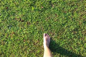 pies masculinos pisando hierba verde foto